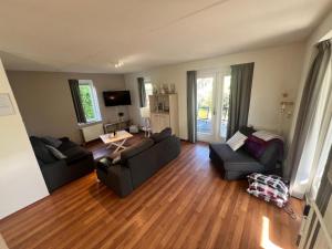 a living room with two couches and a wooden floor at Aquadelta - Casa Claudia in Bruinisse