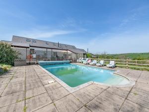 a swimming pool in front of a house at Wheelwright Barn in Llangain