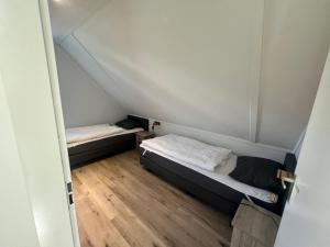 two beds in a small room with wooden floors at Aquadelta - Casa Claudia in Bruinisse