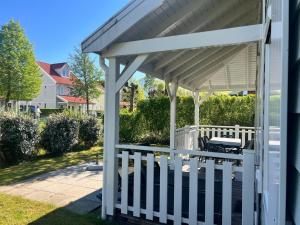 a white pergola with a table on a porch at Aquadelta - Casa Claudia in Bruinisse
