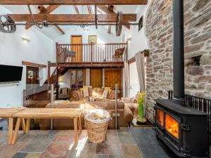 a living room with a fireplace and a stone wall at Wheelwright Barn in Llangain