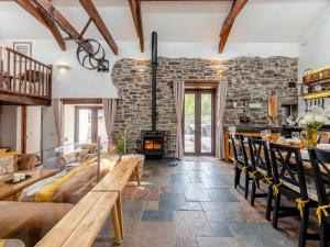 a living room with a fireplace and a stone wall at Wheelwright Barn in Llangain