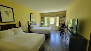 a hotel room with two beds and a television at Plantation Resort on Crystal River in Crystal River +41 photos