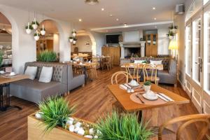 un soggiorno con tavoli e sedie e un ristorante di Alcanada Golf Hotel a Port d'Alcudia