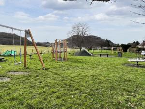 an empty playground with swings in a park at Willesdene Cottage in Abernethy