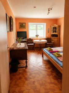 a bedroom with a bed and a living room at Pension Greifswald in Dargelin