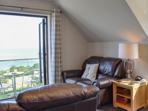 a living room with a leather couch and a window at Woodlea Cottage 1 in Dippin