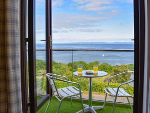a table and chairs on a balcony with a view of the ocean at Woodlea Cottage 1 in Dippin