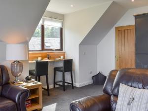 a living room with a couch and a desk at Woodlea Cottage 1 in Dippin