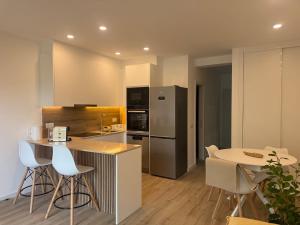 a kitchen with a refrigerator and a table with chairs at Apartamentos Mar-Sol Villas in Vilamoura