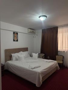 a bedroom with a large bed with white sheets at Hotel Ibiza in Eforie Nord +12 photos