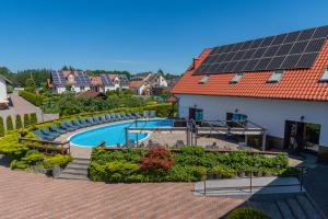 a swimming pool with solar panels on a house at Baron in Sztutowo