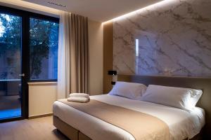 a bedroom with a large bed and a large window at Sant'Angela Rooms in Foligno