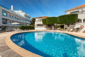 una grande piscina blu di fronte a un edificio di Alcanada Golf Hotel a Port d'Alcudia