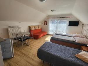 a bedroom with two beds and a table and a couch at Apartmány BOSS in Liptovský Mikuláš