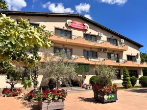 a building with flowers in front of it at TROPHAEUM TRAIANI in Adamclisi +4 photos