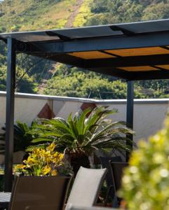 a table and chairs with a plant on a balcony at Serra Negra Paladium Hotel in Serra Negra