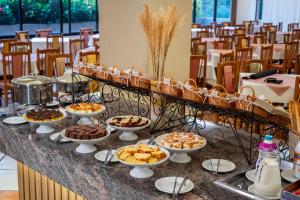 a buffet with bowls of food on a table at Serra Negra Paladium Hotel in Serra Negra