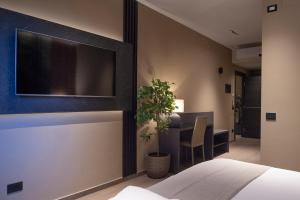 a bedroom with a tv and a table with a plant at Sant'Angela Rooms in Foligno