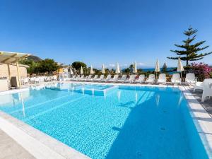 a swimming pool with chairs and blue water at Ninfa Sul Mare Apartments - Piscina con Area Relax e Parcheggio Gratuito in Capo Vaticano