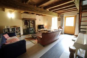 a living room with a couch and a fireplace at Les cheyroux in Saint-Léger-Magnazeix