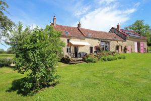 a house with a green yard in front of it at Les cheyroux in Saint-Léger-Magnazeix