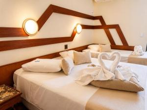 two beds in a hotel room with a heart on them at Serra Negra Paladium Hotel in Serra Negra