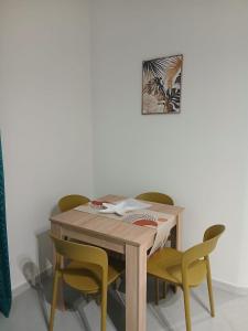 a table with four chairs and a picture on the wall at Dolcecasa in Misilmeri