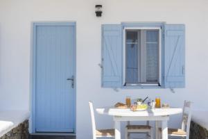 a room with a table and a blue door at Lefkanemos in Tourlos