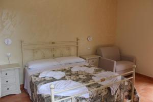 a small bedroom with a bed and a chair at Agriturismo Il Vecchio Carrubo in Castellammare di Velia