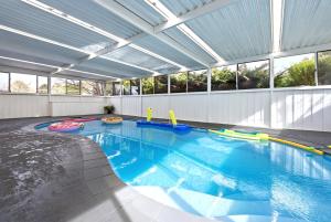 a large swimming pool with an indoor swimming poolvisor at Blue Willow Bathurst Country Getaway in Bathurst