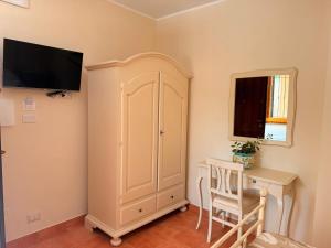 a room with a white cabinet and a desk at Agriturismo Il Vecchio Carrubo in Castellammare di Velia