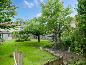 a garden with a fence and trees in a yard at Rose Croft in Pickering