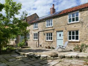 a stone house with a chair in front of it at Rose Croft in Pickering
