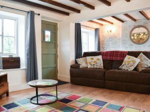 a living room with a brown couch and a table at Rose Croft in Pickering