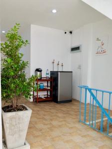 a room with a potted plant and a refrigerator at We Inn in Bangkok