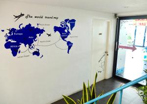 a map of the world mural on a wall in an office at We Inn in Bangkok