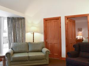 a living room with a couch and a chair at Pine Tree Cottage - Uk45925 in Ballater