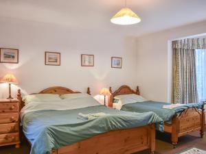 two twin beds in a bedroom with a window at Pine Tree Cottage - Uk45925 in Ballater