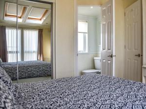 a bedroom with a mirror and a bed and a bathroom at Sandbank in Bacton