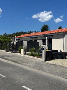 a white building with a fence next to a street at Résidence les 3 volcans 4 étoiles in Clermont-Ferrand