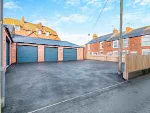a garage with two garage doors in a parking lot at Dunlin in Filey