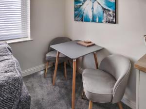 a room with two chairs and a table and a bed at Dunlin in Filey