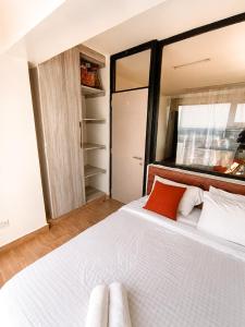 a bedroom with a large white bed and a closet at Starla Apartment in Kinoo