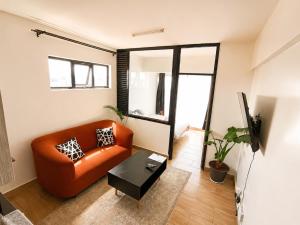 a living room with an orange couch and a table at Starla Apartment in Kinoo