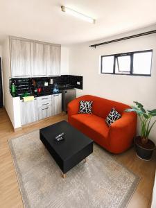 a living room with a red couch and a table at Starla Apartment in Kinoo