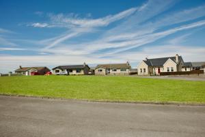 a row of houses with green grass in front of a street at Avalon in Bundoran