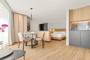 a hotel room with a bed and a table and chairs at Nodo Hotel in Manizales