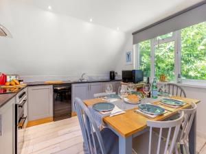 a kitchen with a wooden table with chairs and a table and a dining room at Valley Lodge - Uk49228 in Gunnislake