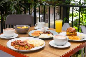 a table topped with plates of breakfast food and orange juice at Blues Suites Medellín in Medellín +45 photos